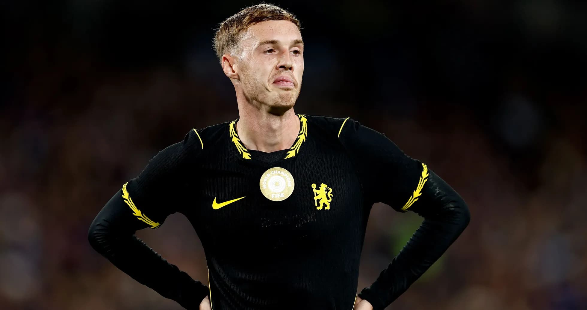 Player in black kit standing with hands on hips
