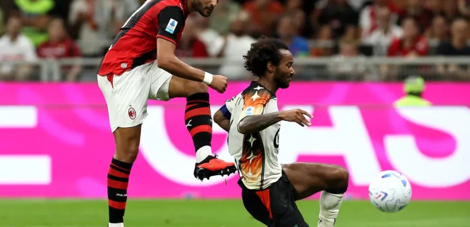 AC Milan player challenging Venezia opponent during match