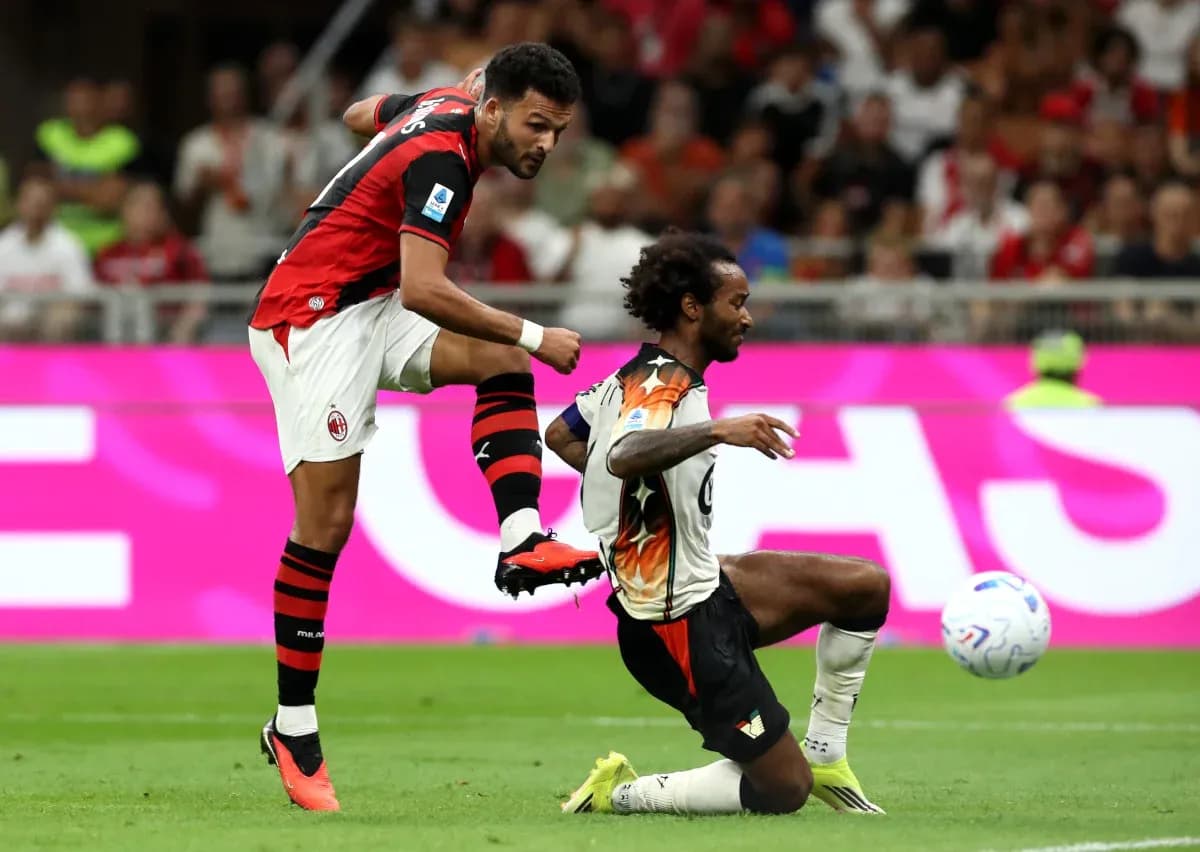 AC Milan player challenging Venezia opponent during match