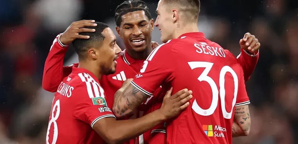 Three players celebrating a goal in red jerseys