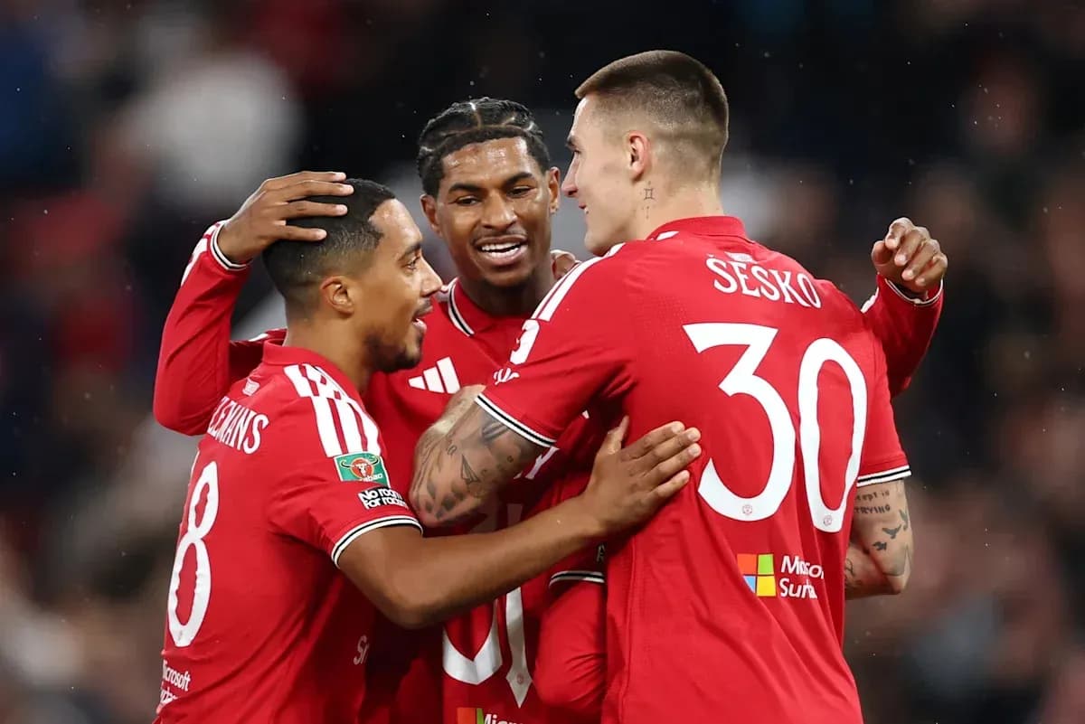Three players celebrating a goal in red jerseys