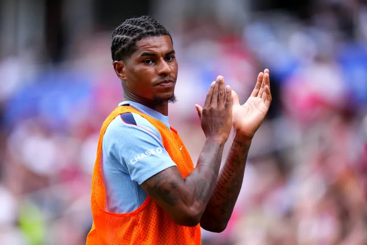 Player in warm-up jersey clapping on the sidelines