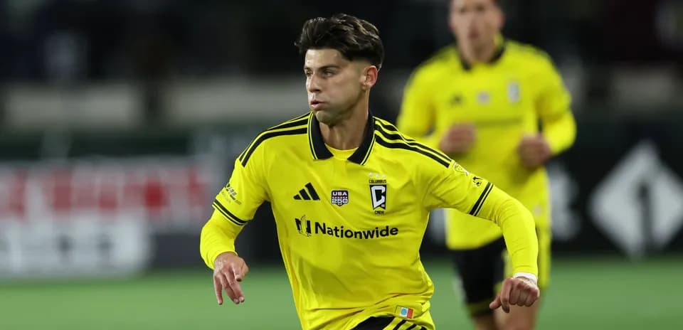 Columbus Crew player in yellow jersey running