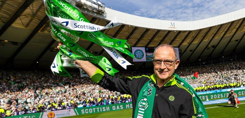 Man holding trophy with Celtic colors at stadium