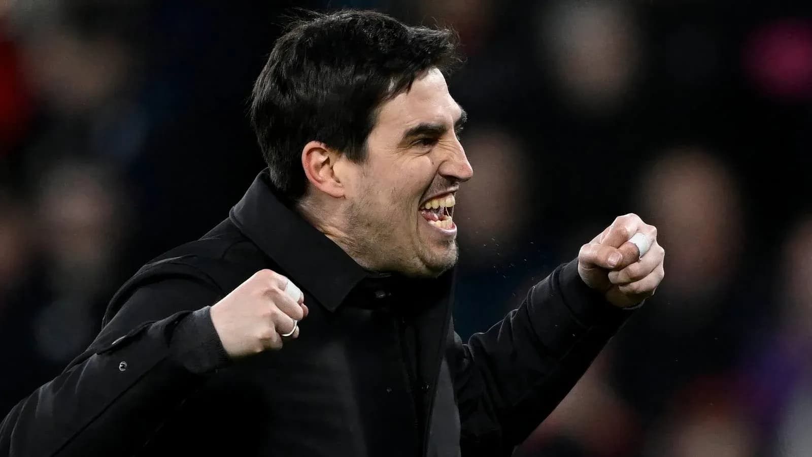 Coach celebrating with clenched fists on sidelines