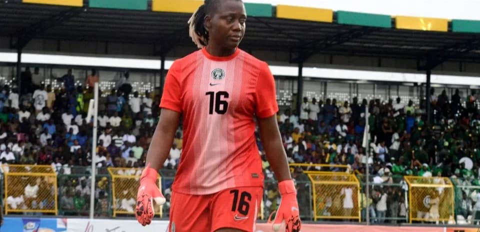 Goalkeeper in red kit walking on the field
