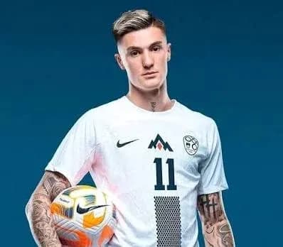 Player in white jersey holding a soccer ball