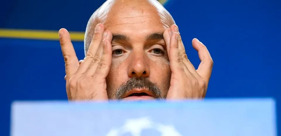Manager speaking at press conference with hands on face