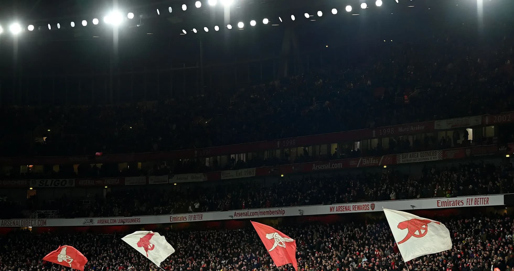 Fans waving flags at Emirates Stadium during match