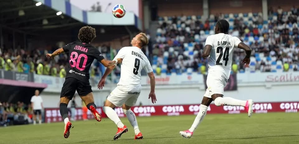 Players contesting for the ball during KuPS match