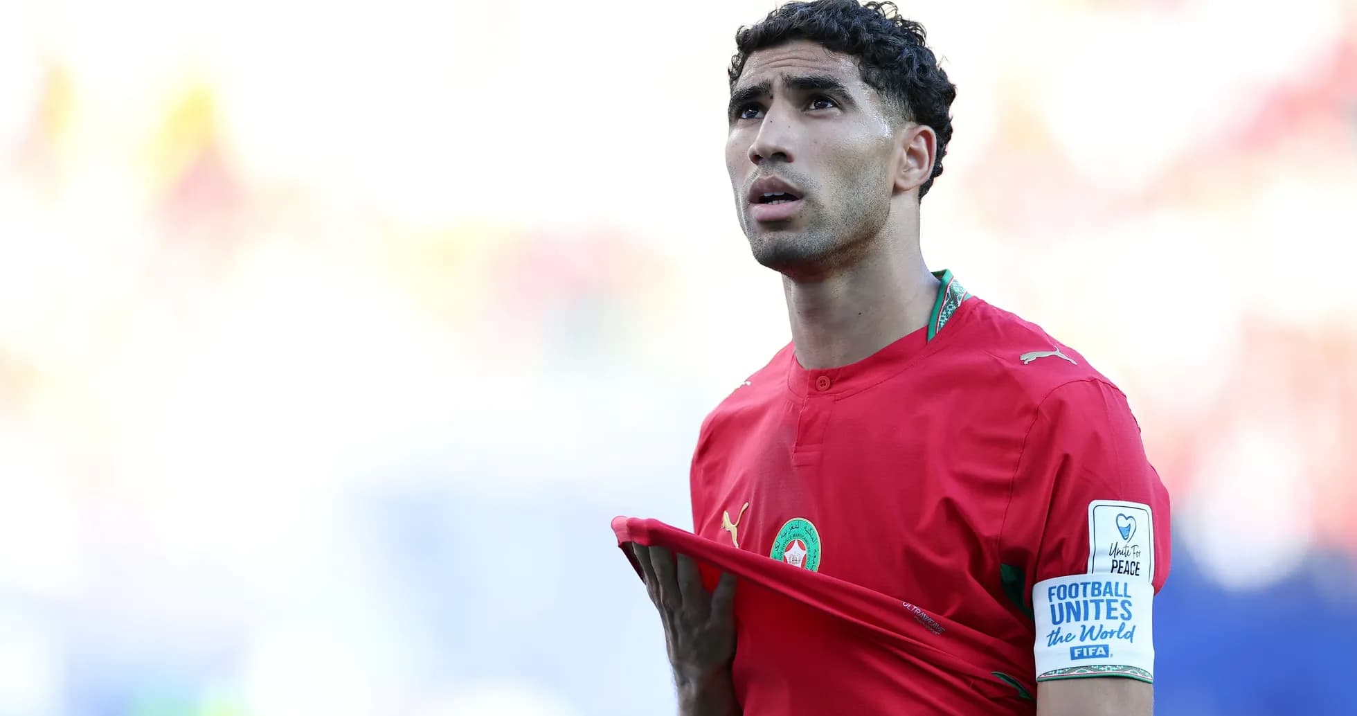 Player adjusting jersey during match in red kit