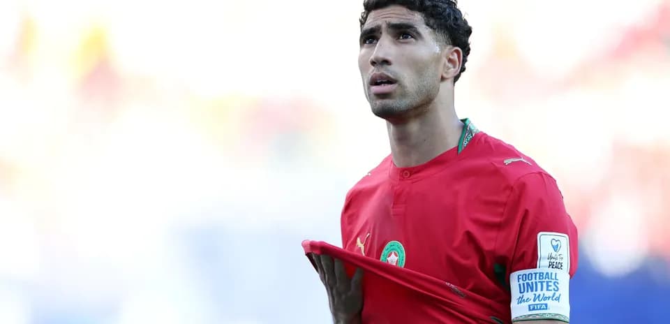 Player adjusting jersey during match in red kit