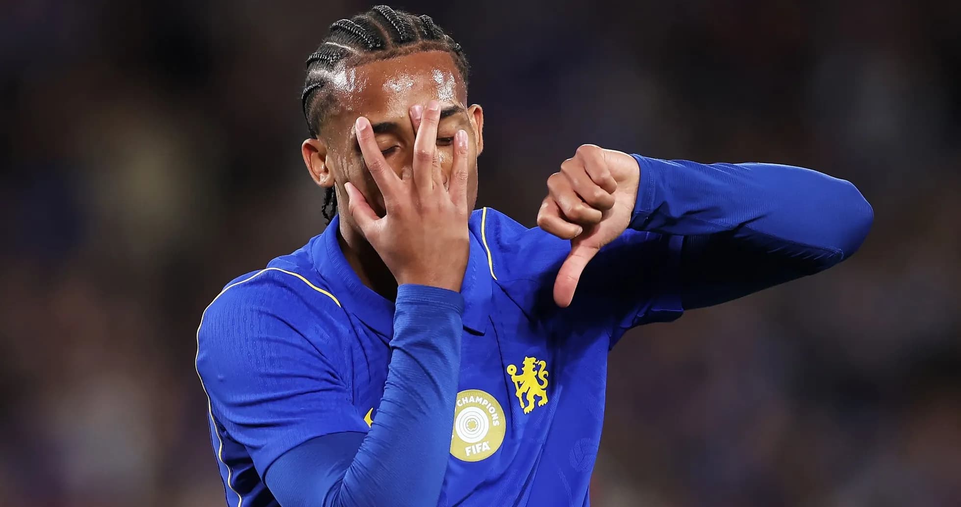 Player in blue jersey showing disapproval gesture