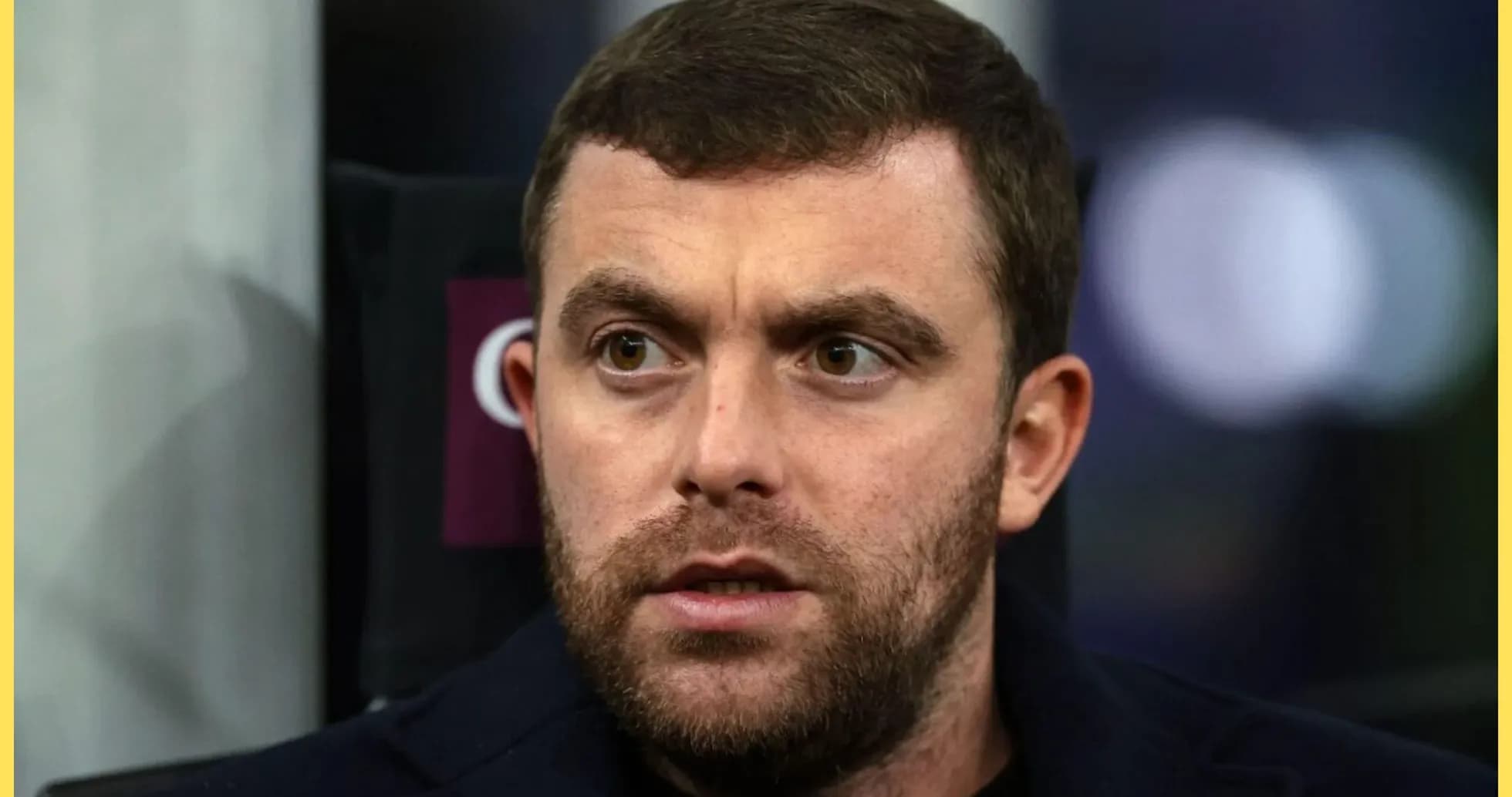 Man with short hair and beard in stadium seat