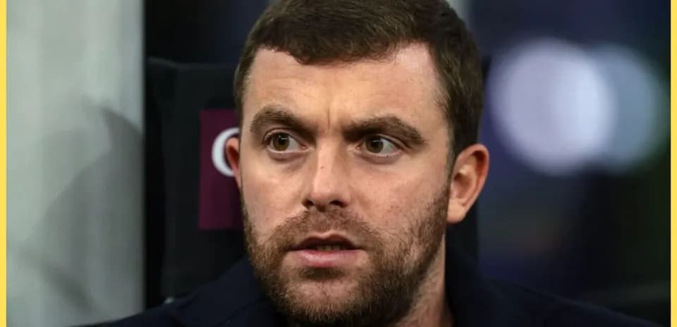 Man with short hair and beard in stadium seat