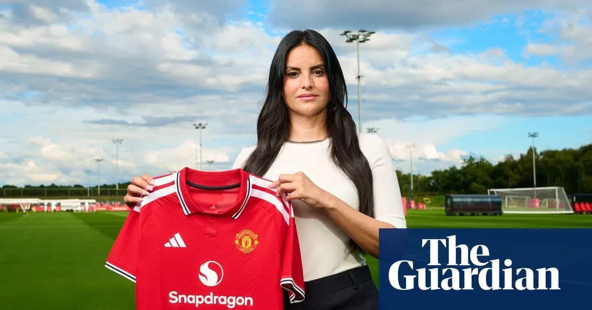 Woman holding Manchester United jersey at training ground