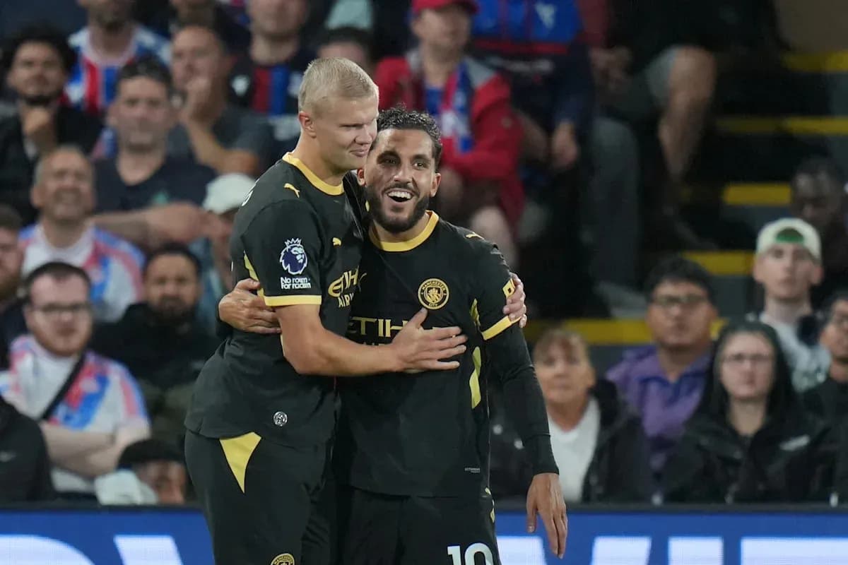 Two Manchester City players celebrating a goal together