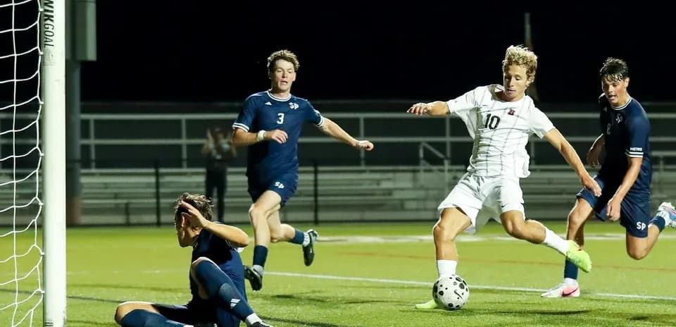 Player attempting to score as goalkeeper defends goal
