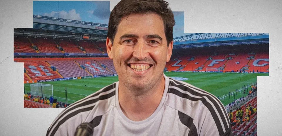Man smiling in front of Anfield stadium