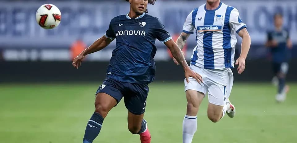 Player in blue jersey dribbling the ball past opponent