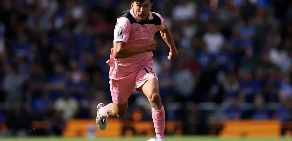 Player in pink jersey sprinting with ball during match