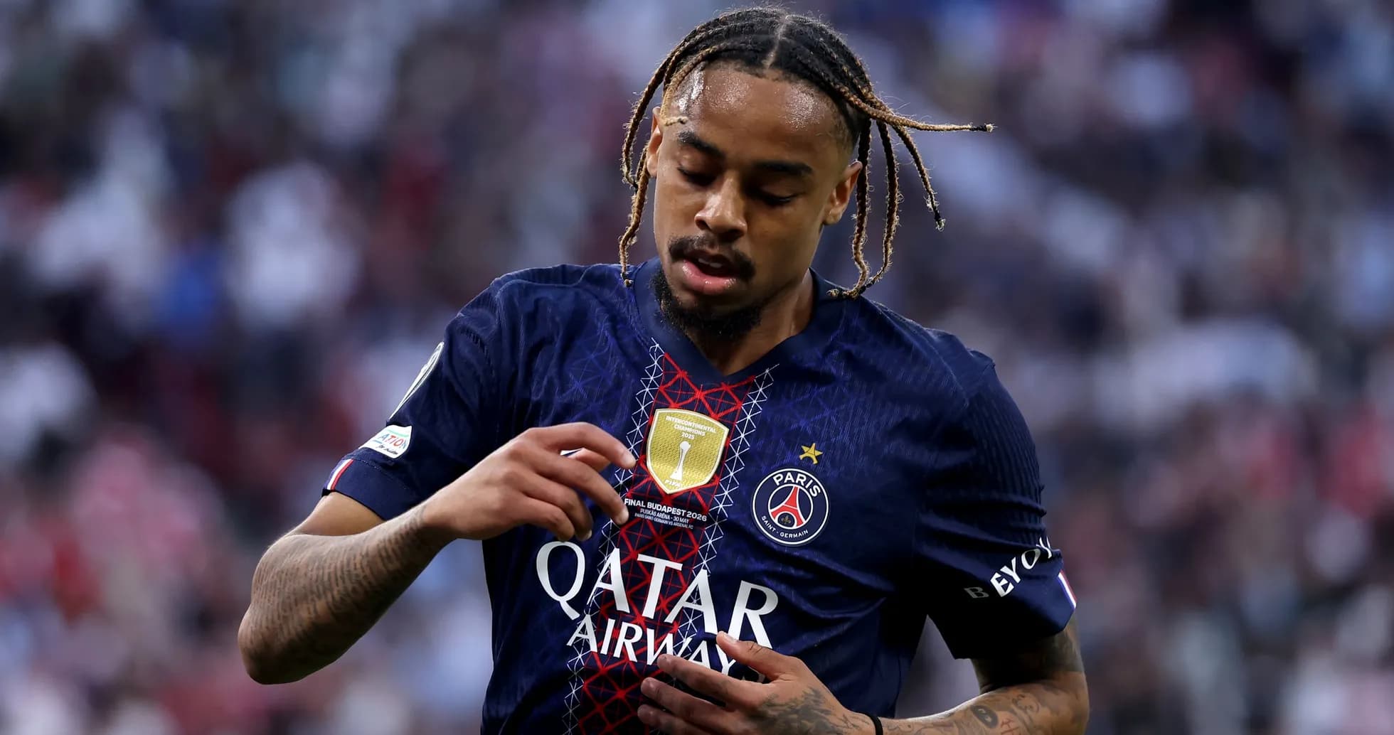 Player inspecting club badge on jersey during match