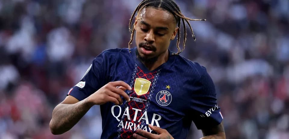 Player inspecting club badge on jersey during match