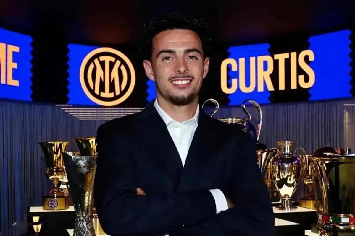 Man in suit posing in front of trophies