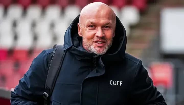 Man in a black coat entering stadium