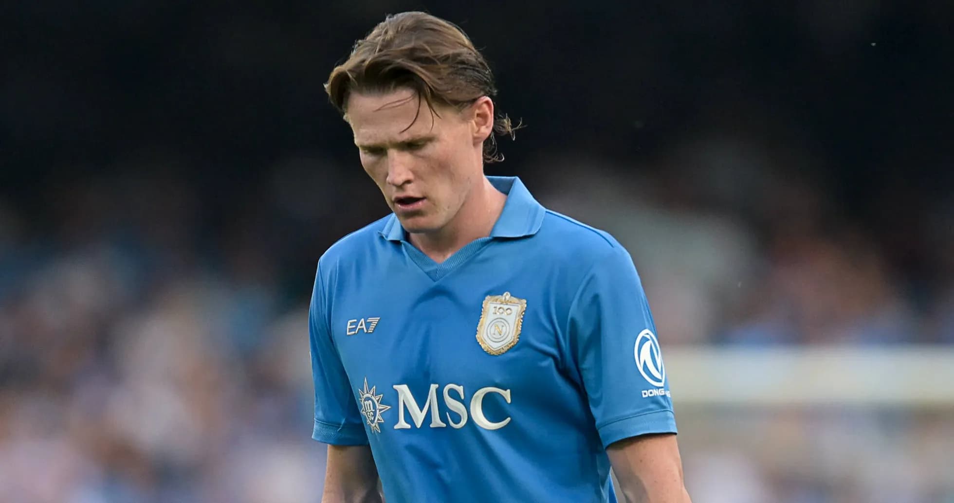 Player in blue jersey walking with head down