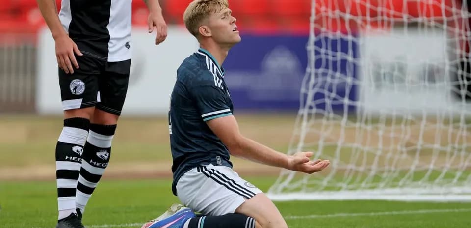 Player kneeling on pitch after missing a shot