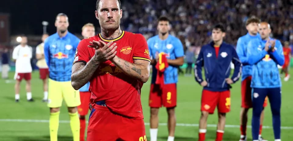 Player applauding with teammates in background after match