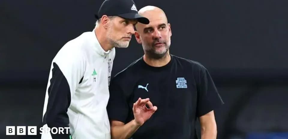 Two football coaches discussing strategies on the pitch