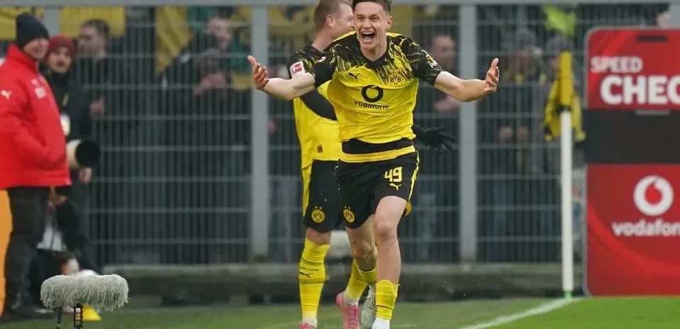 Player celebrating a goal with teammates on field