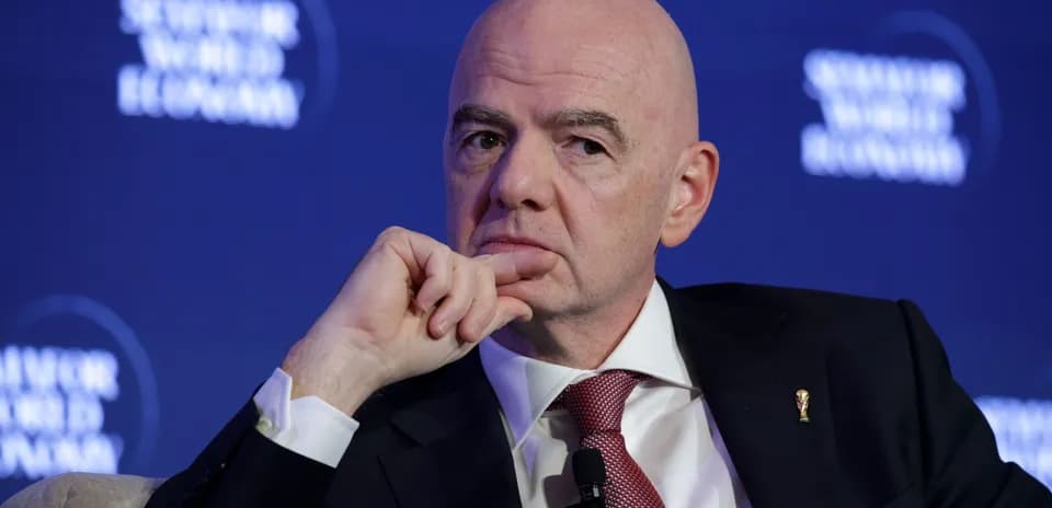 Man in suit during a conference, hand on chin