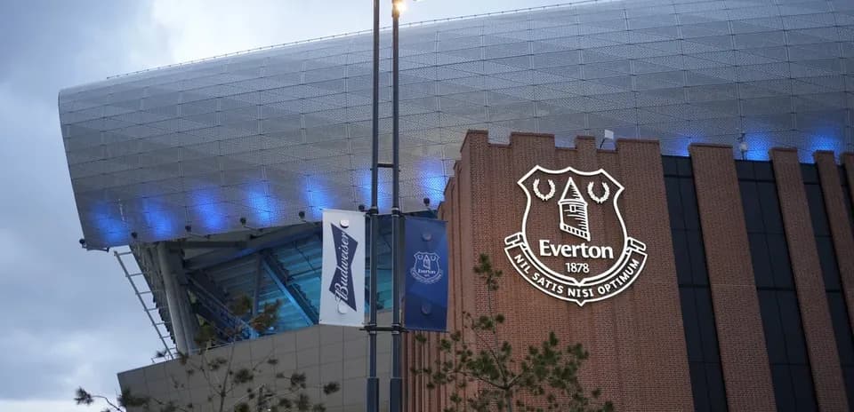 Everton FC logo on stadium exterior at dusk