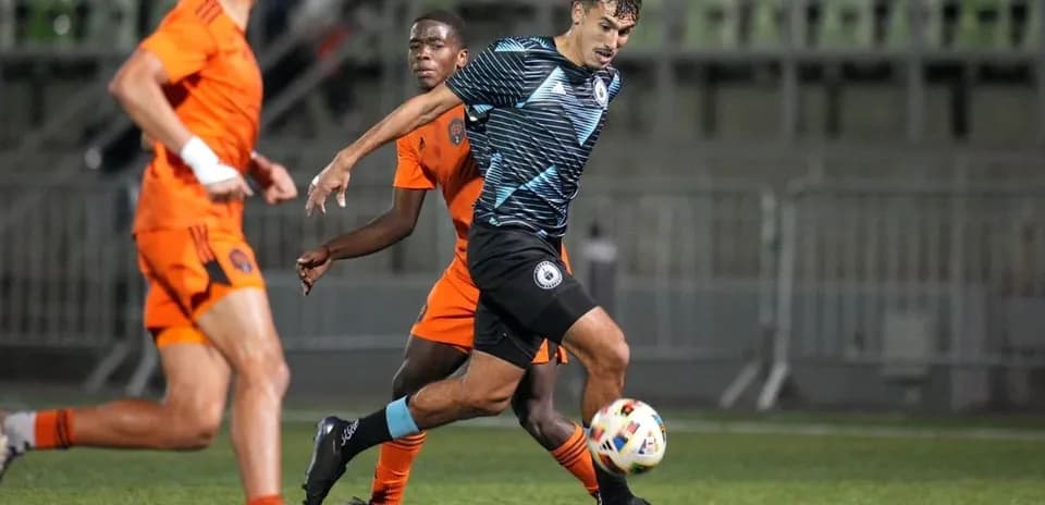 Player dribbling the ball during Tacoma Defiance match