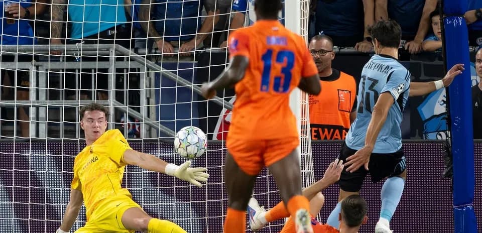 Goalkeeper attempting to save during UEFA match