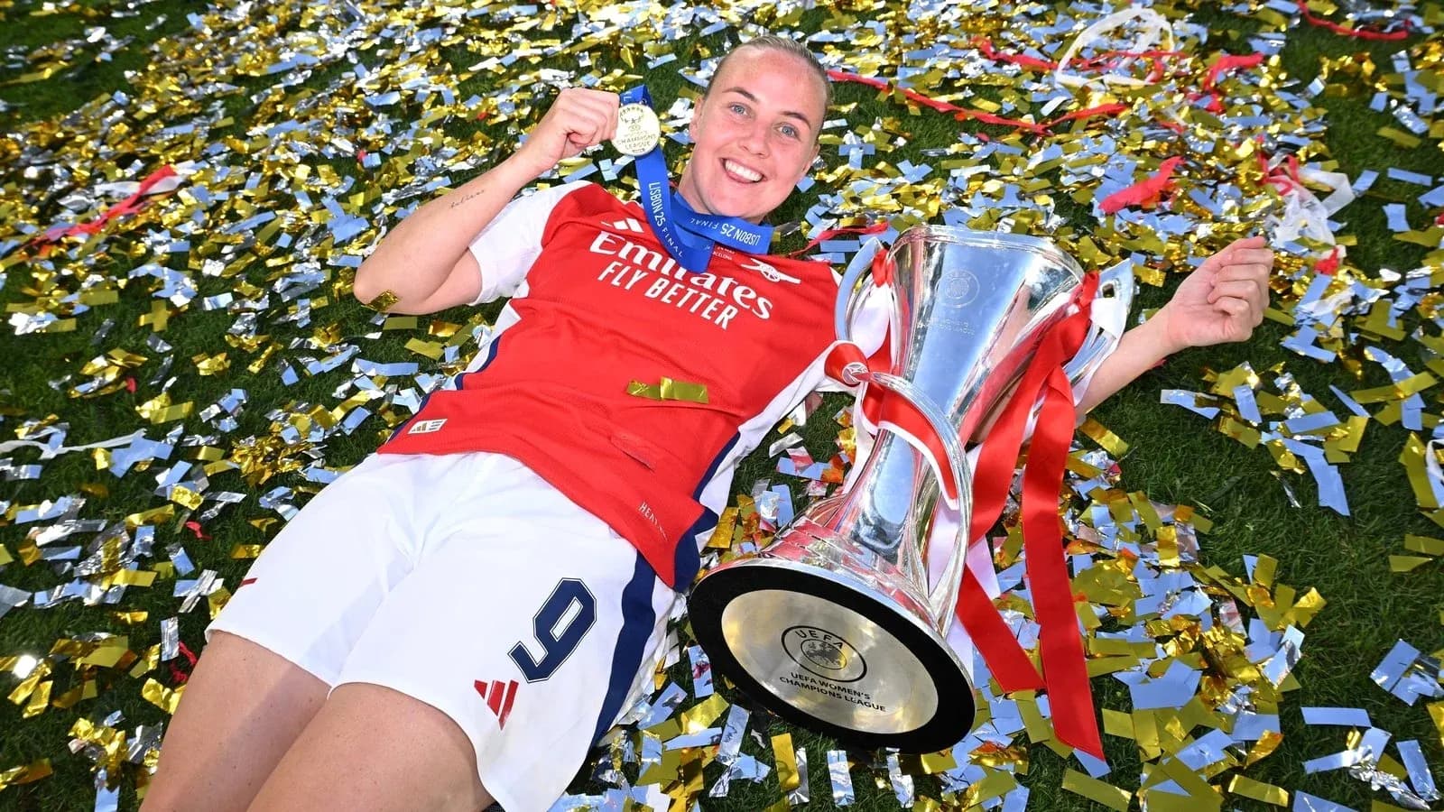 Player celebrating with trophy and medal on field