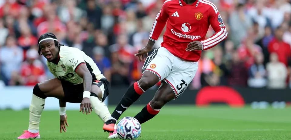 Manchester United player dribbling past opposing defender