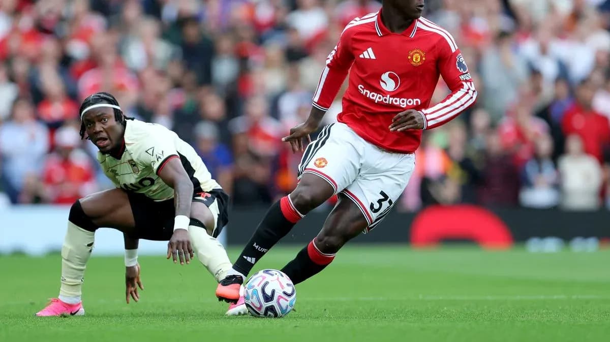 Manchester United player dribbling past opposing defender