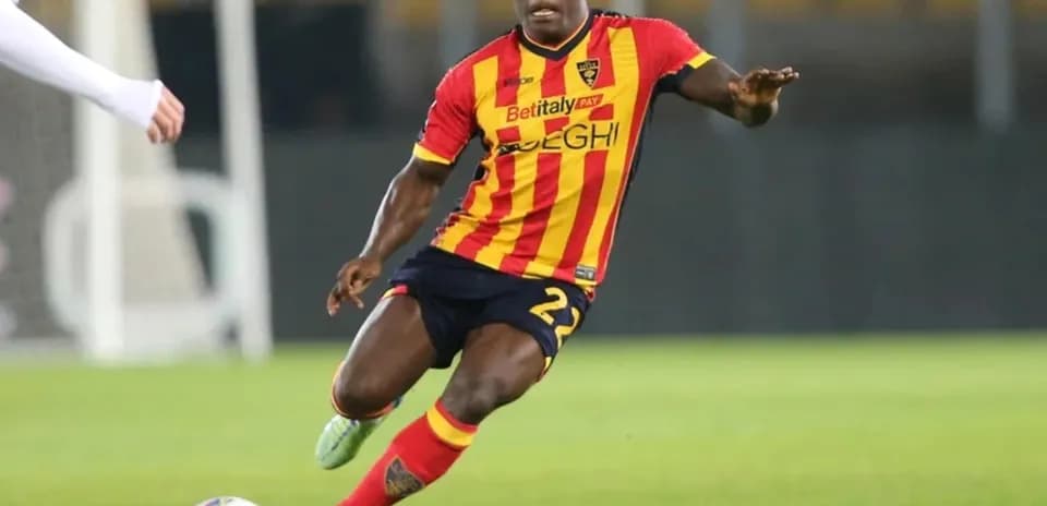 Player in yellow and red jersey dribbling ball on field