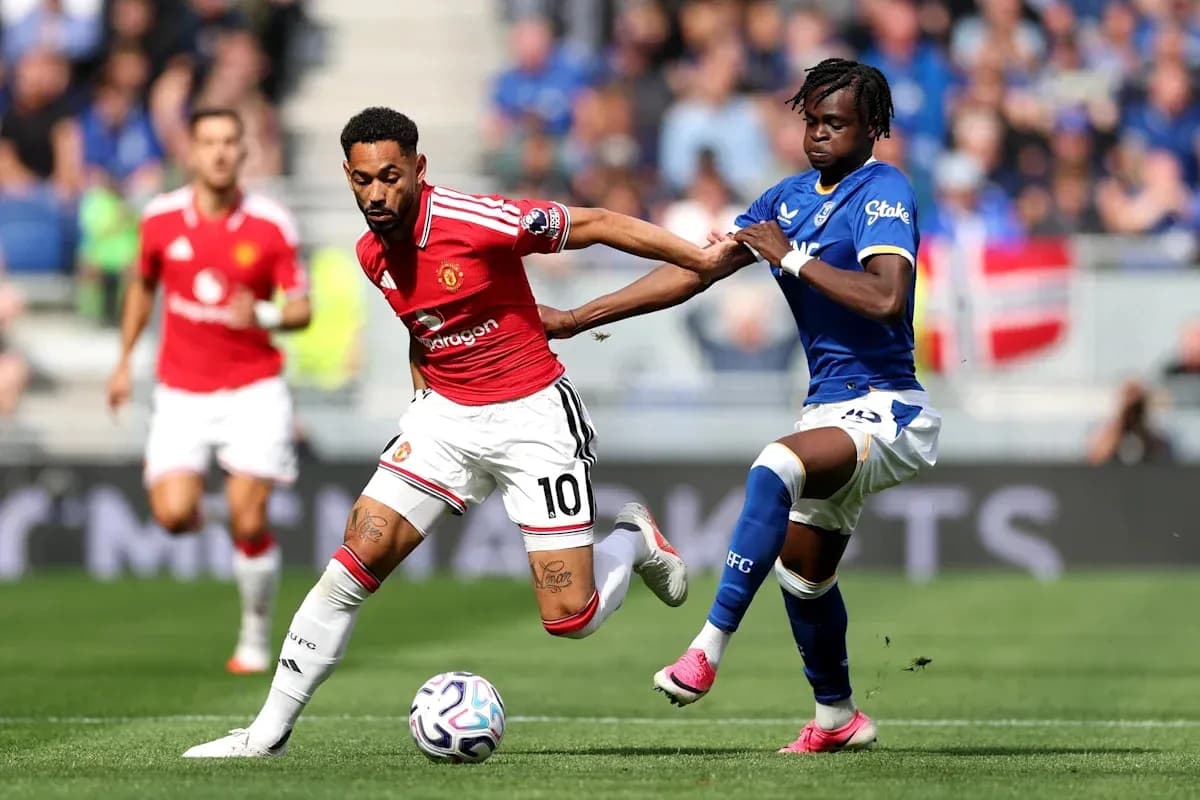 Player in red dribbling while being challenged by opponent