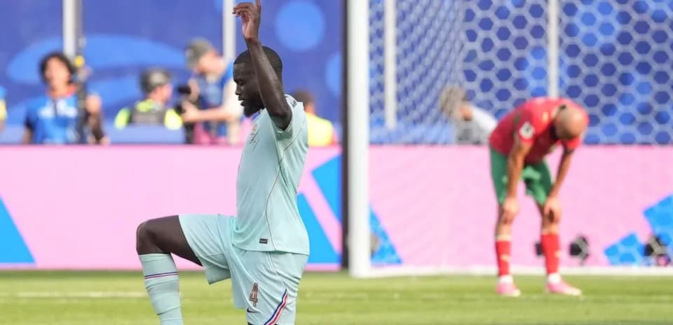 Player kneeling on pitch during football match