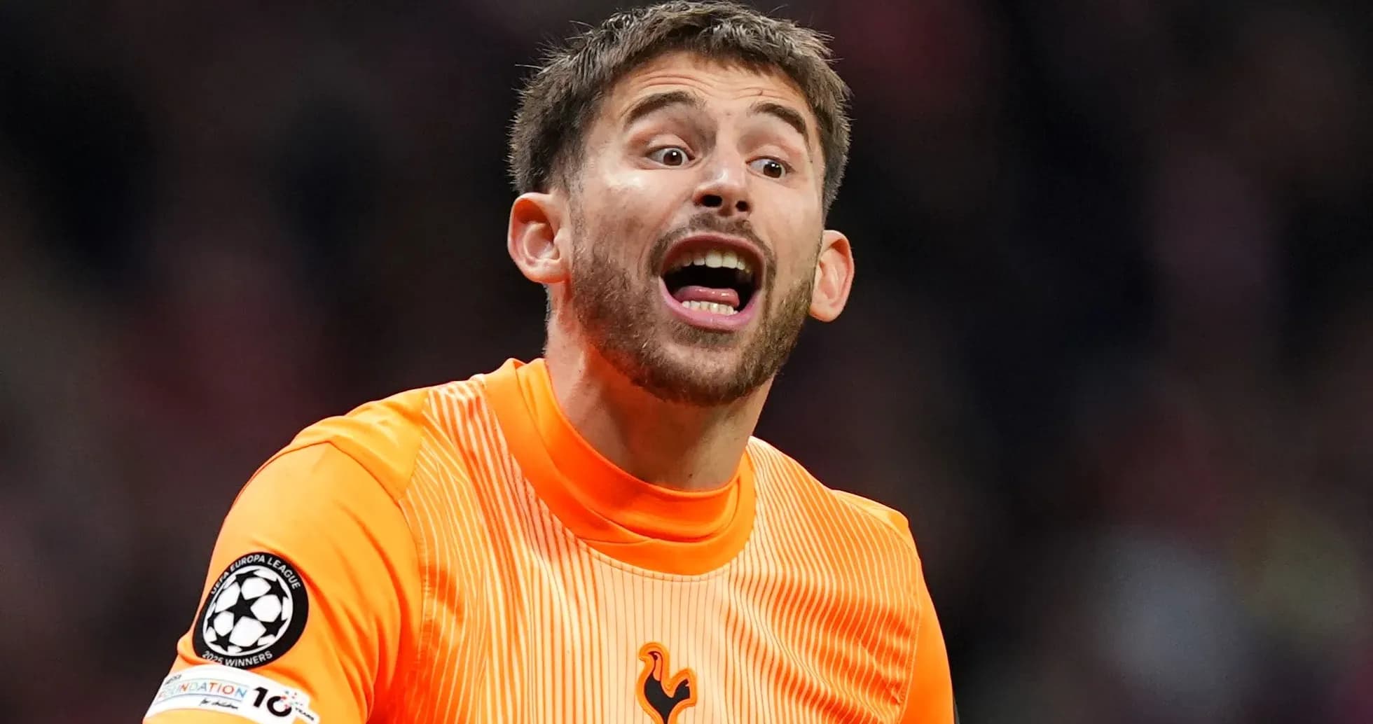 Goalkeeper in orange kit shouting during match