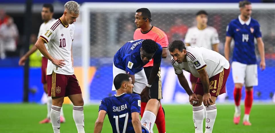 Players attending to an injured teammate during match