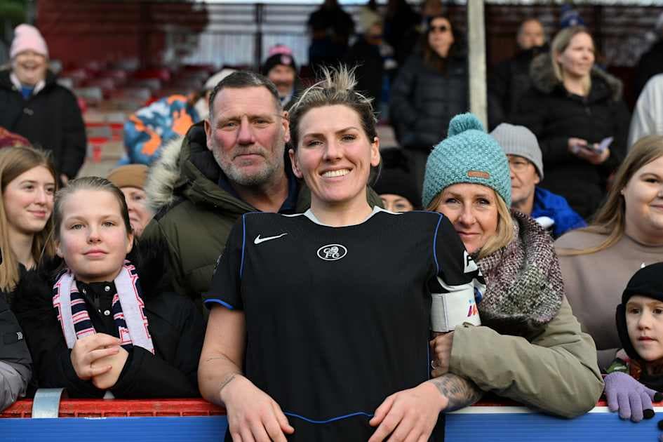 Player posing with fans in the stands