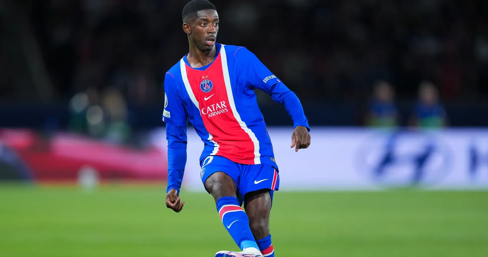 Player in PSG kit dribbling on the field
