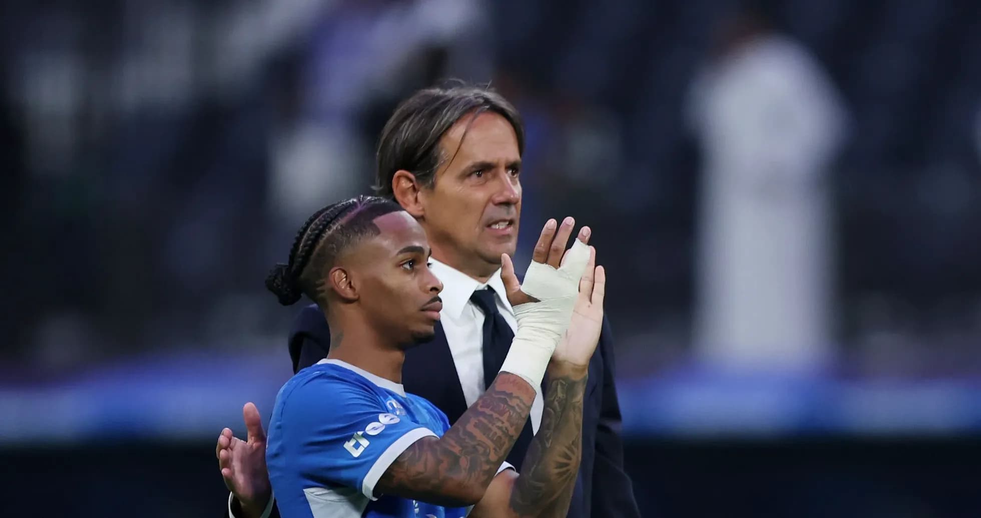 Player and coach interacting on the pitch post-match