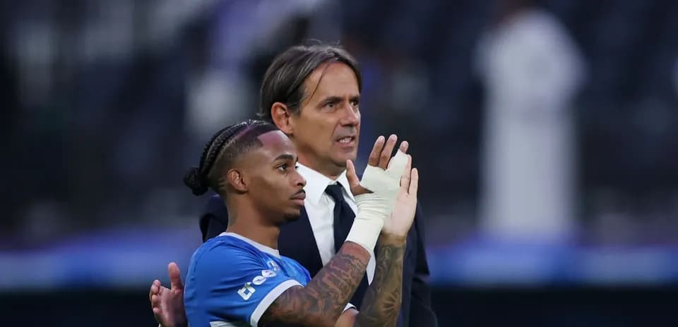 Player and coach interacting on the pitch post-match
